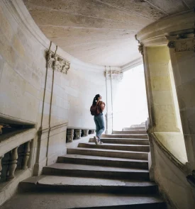 Femme qui monte les escaliers du château de Chambord