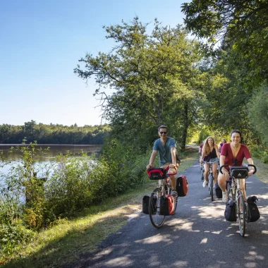 Cyclistes sur la route au bord de l'étang