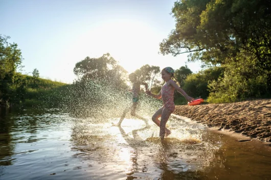 Baignade dans un plan d'eau. Deux enfants s'élançant dans l'eau